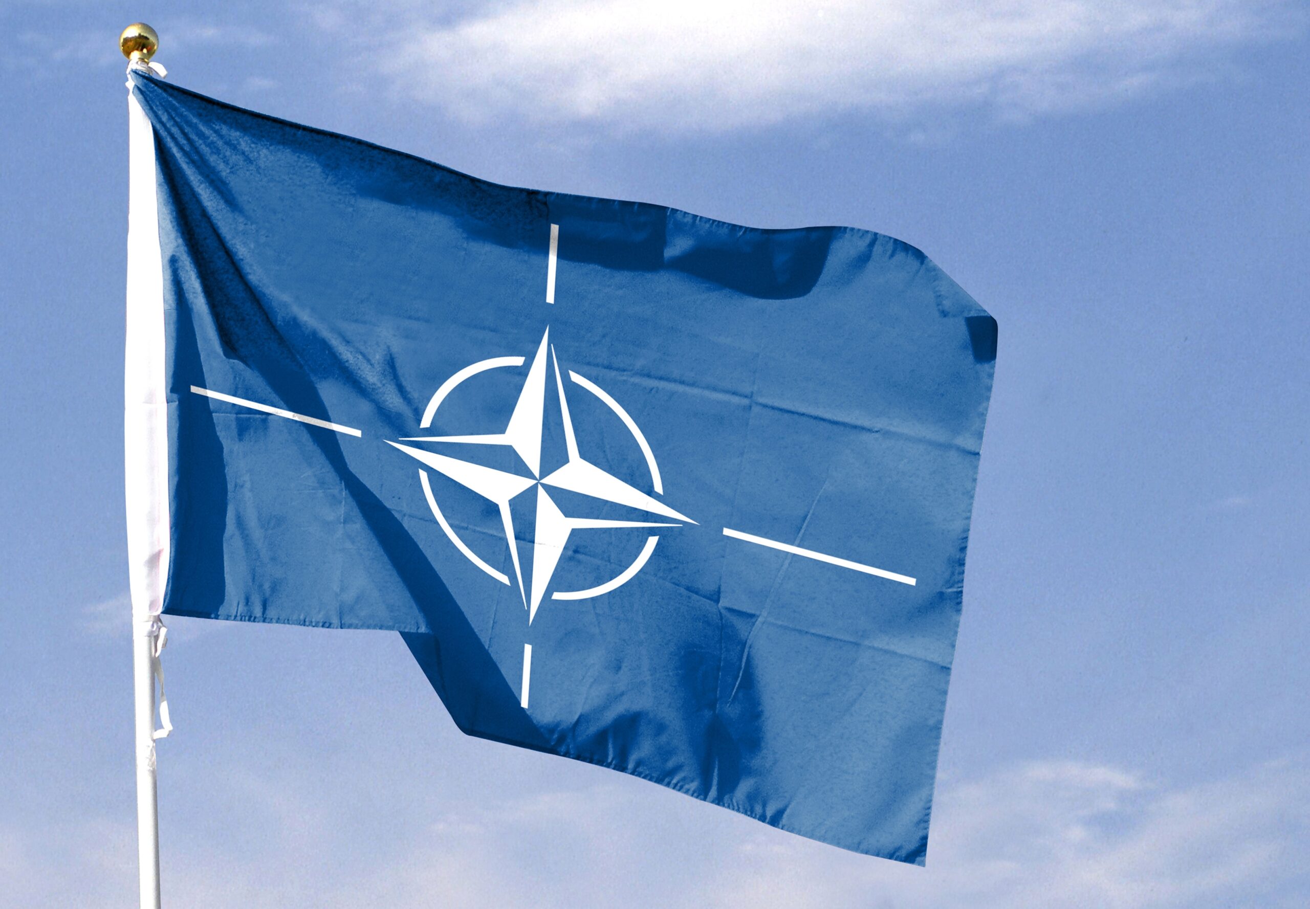 North,Atlantic,Treaty,Organization,Flag,In,Cloudy,Sky.,Waving,In